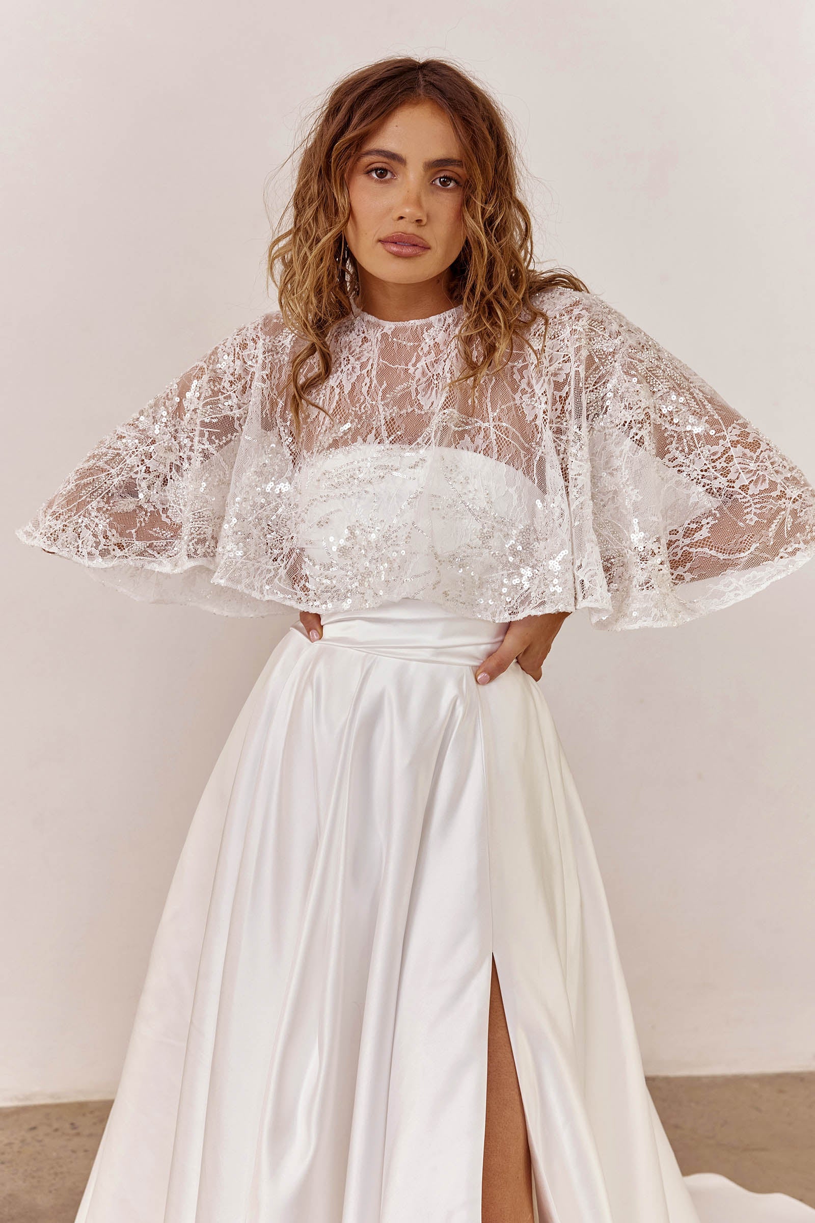 Woman wearing a satin wedding dress with a sheer bridal cape_XS_