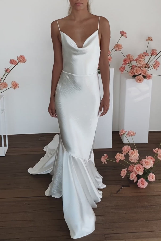 A model posing in a satin wedding dress