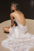 woman wearing a white lace backless dress with thin straps and delicate chain jewellery across her back_XS_