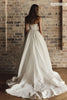 A woman wearing a strapless white wedding gown with a fitted bodice and full skirt