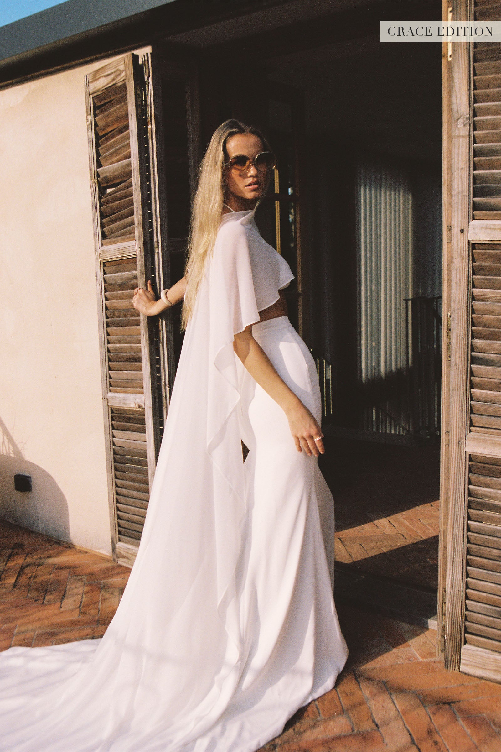 A woman models a sheer cape and a long wedding skirt_XS_