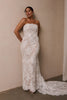 A woman wearing a strapless white lace wedding gown with a long train_L_