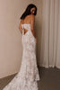 A woman wearing a strapless white lace wedding gown with a long train_L_
