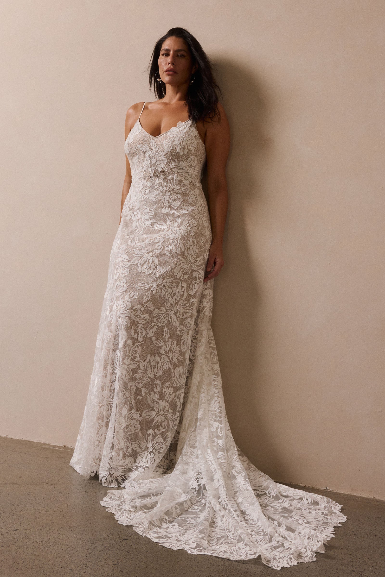 woman wearing a white lace backless dress with thin straps and delicate chain jewellery across her back_L_