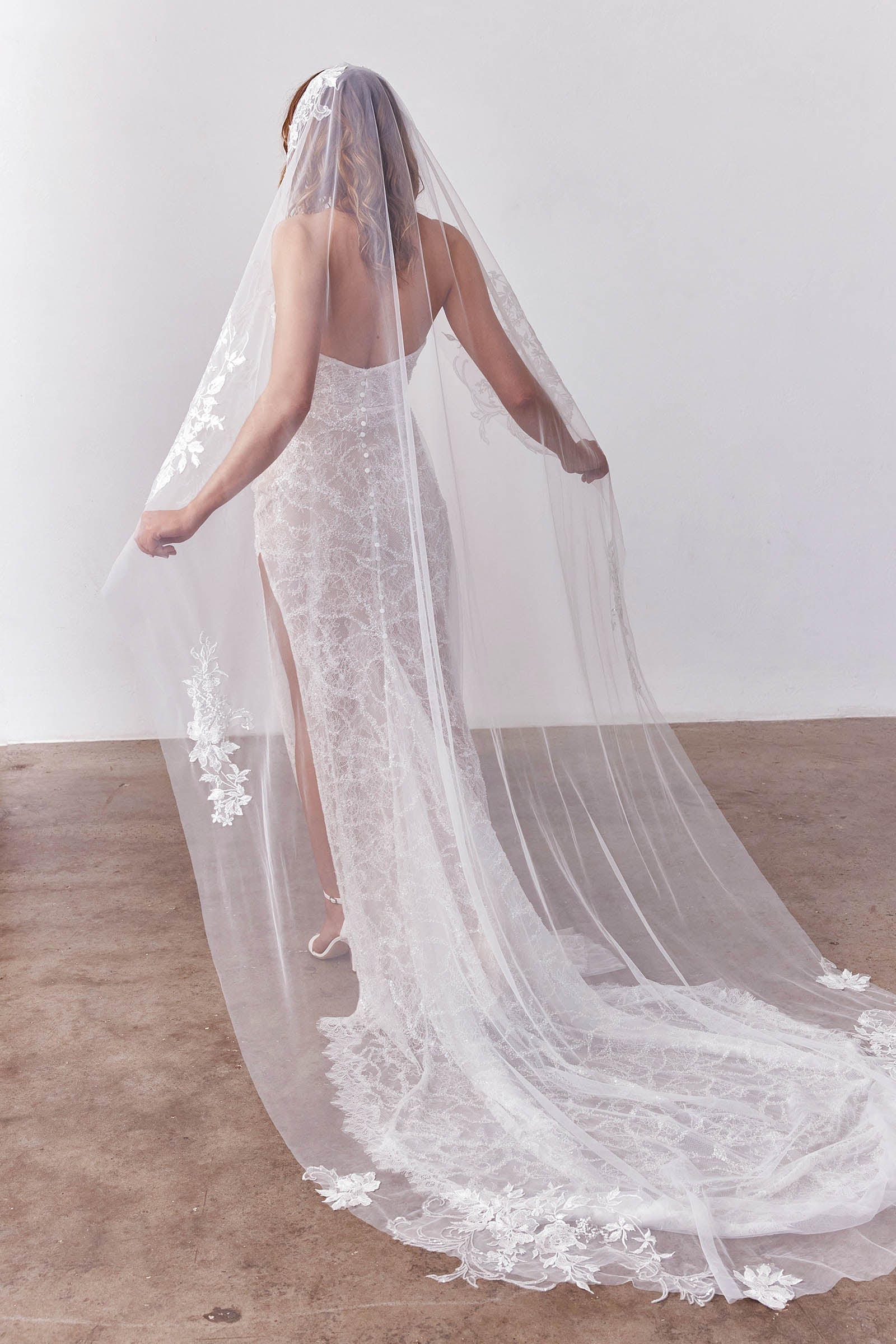 Bride wearing a wedding dress and long veil with floral details_XS_