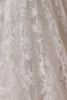 A close-up of a sheer, textured fabric with an intricate floral jacquard pattern in light beige and off-white tones.