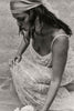 Woman in a lace wedding dress with a headscarf and earrings.