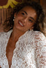 Woman wearing a white lace wedding gown and pearl earrings