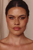 Close-up of a woman wearing pearl earrings with a neutral background